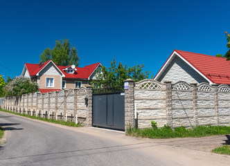 Modern private house behind the fence in summer