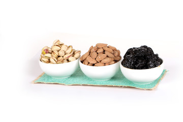 Assorted nuts on white, dry fruits, mix nuts, roasted almond, prunes, pistachio