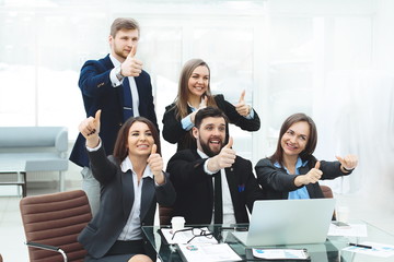 business team with thumbs up and vote for a decision near the desktop