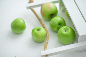 fresh green apples in a box on white background