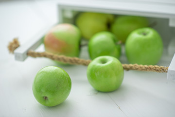 fresh green apples in a box on white background