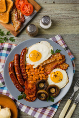 Full English breakfast, with sausage, mushrooms, beans and a fried egg.