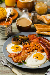 Full English breakfast, with sausage, mushrooms, beans and a fried egg.