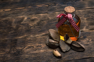 Brazil nut oil in a bottle on brown wooden table background.