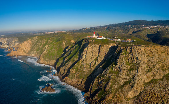Aerial; drone view of westernmost point of mainland Europe, Cabo da Roca; touristic attaction of the country; edge of the Earth with steep stony slopes and turquoise water; dangerous cliff Peninsula