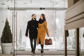 Happy couple entering at the hotel lobby from outddors