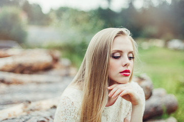 Close up natural portrait of young happy cute cheerful caucasian beautiful girl witn long natural blondie hair walking in park in summer evening