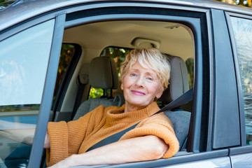 Smiling senior woman taxi driver