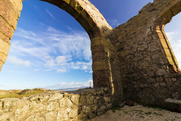 Fototapeta premium View from the remains of St Dwynwen's Church on Llanddwyn Island with the Snowdonia Mountain Range behind, Anglesey, North Wales