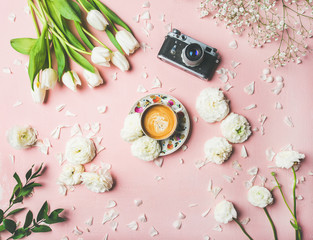 Fototapeta na wymiar Flat-lay of cup of coffee, film camera, fresh white tulips and buttercup flowers over pink background, top view. Spring vibes or Women's Day holiday concept