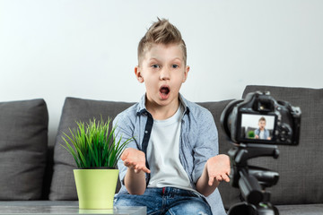 The boy is sitting in front of a SLR camera, close-up. Blogger, blogging, technology, earnings on the Internet. copy space.