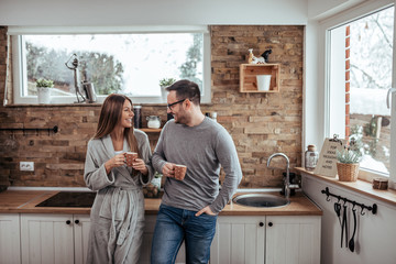 Weekend mornings. Millennial couple having tea on winter morning.