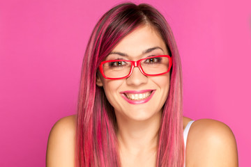 a happy woman with a pink hair and glasses on pink background