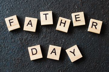 Father's day concept. Wooden letters on dark background.