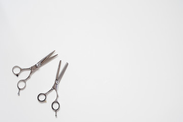 flat lay open pair of  hairdressing scissors isolated on white background in the down left corner 