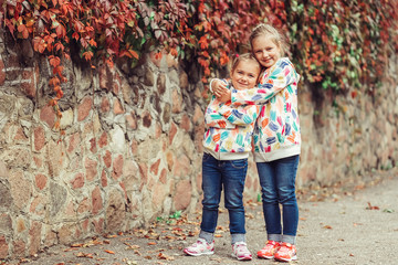 New generation. Young positive girls outdoors having fun together. Happy, preshhooler girls playing in park together