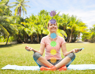 fitness, yoga and healthy lifestyle concept - happy woman meditating in summer park with seven...