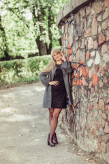 Happy cheerful portrait of young caucasian blondie woman with long hair walking outdoors in park