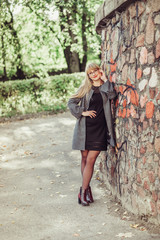 Happy cheerful portrait of young caucasian blondie woman with long hair walking outdoors in park