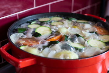Red pot with boiling soup.