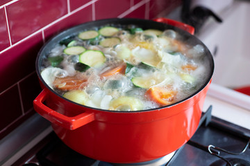 Red pot with boiling soup.