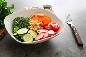 Bowl with fresh ingredients for vegetable salad on table. Diet food