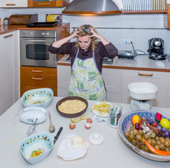 Desperate housewife with hands in the hair for mess in kitchen she will have to fix