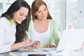 Fototapeta premium Two young businesswomen working at modern office