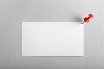 Blank business card and drawing pin on light background