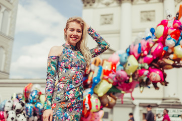 Street stylsh portrait of young blodnie cheerful girl walking in the old town. Vacation, travelling, beauty concept