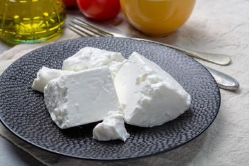 Fresh young soft white Feta cheese on black plate