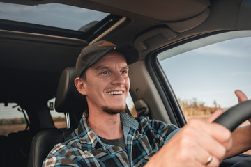 young man driving a car or truck.