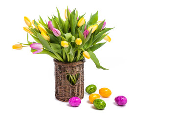 Easter. Easter colored eggs. Flowers Tulips. A bouquet of colorful tulips in a wicker vase. Congratulations on Easter. Isolate on white background