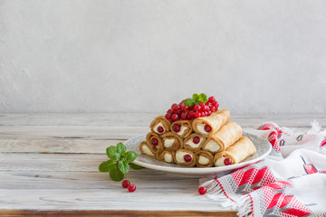 Pancake rolls with ricotta and mascarpone with red currants.