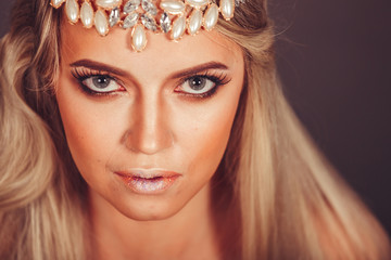 Close up portrait of gorgeous young fashionable model with long blondie hair and jewelery