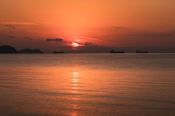 Obraz premium view of the orange sun falling over the sea and the beautiful sky