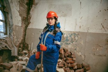 Destroying gender stereotypes. Woman wearing helmet using different male work tools. Gender...