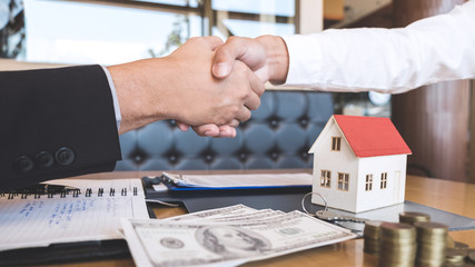 Image of successful deal of real estate, Broker and client shaking hands after signing contract approved application form, concerning mortgage loan offer for and house insurance