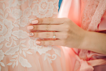 girl holds her wedding dress with her fingers