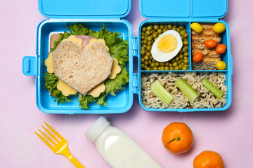 Lunch boxes with tasty creative food for kid on color background