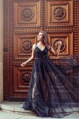 Fashionable close up street portrait of brunette beautiful girl walking in old town of Riga. Beauty, fashion concept