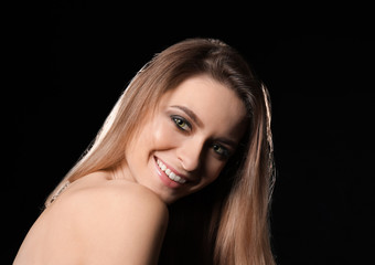 Portrait of beautiful young woman on dark background