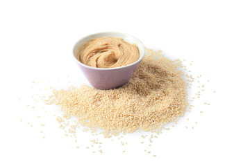 Bowl of tasty tahini with sesame seeds on white background
