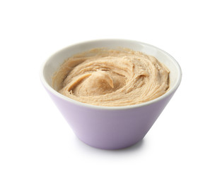 Bowl of tasty tahini on white background