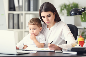 Young mother with her son working in office