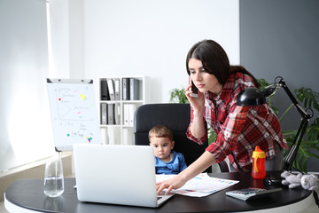 Young mother with her son working in office