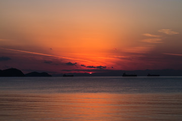 view of the orange sun falling over the sea and the beautiful sky