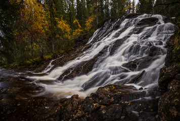 Waterfalls in boreal autumnal forest in Norway.