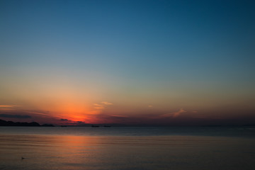 Naklejka premium view of the orange sun falling over the sea and the beautiful sky