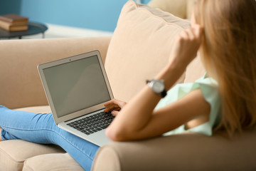 Beautiful young woman using laptop at home